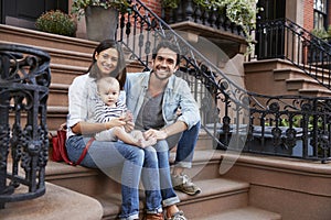 Young family with kids sitting on front stoops