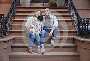 Young family with kids sitting on front stoops