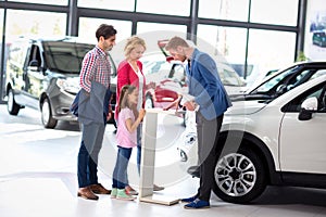 Young family listens carefully car dealers photo