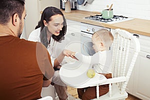 Young family with little cute son on kitchen in morning happy smiling, lifestyle people concept