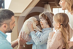 young family with little labrador puppy in front of