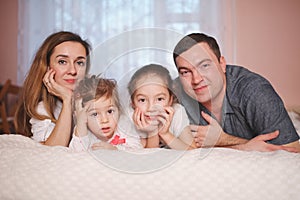 Young family lying in bed at home