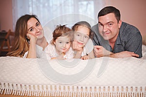 Young family lying in bed at home