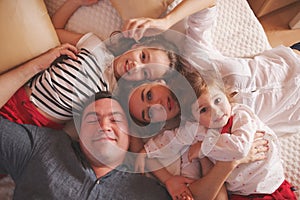 Young family lying in bed at home