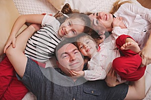 Young family lying in bed at home