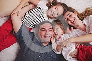 Young family lying in bed at home