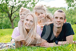 Young family lying on grass in countryside