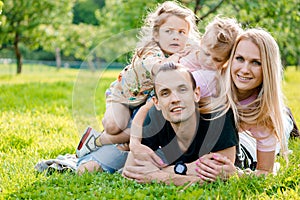 Young family lying on grass in countryside