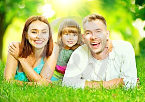Young family lying on green grass