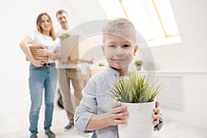 Young family, man woman and child son in new apartments. Boxes with cargo on a white background.