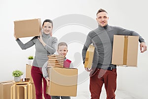Young family, man woman and child son in new apartments. Carried in the hands of cardboard boxes. Boxes with cargo on a