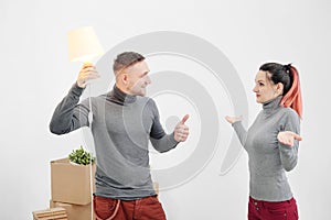 Young family, man and woman in new apartments. A man had an idea. Boxes with cargo on a white background.