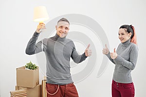 Young family, man and woman in new apartments. A man had an idea. Boxes with cargo on a white background.