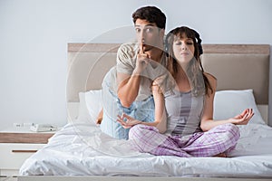 The young family meditating in the bed bedroom