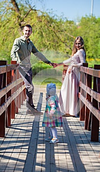 Young family, mother, father, daughter, walk in the city park