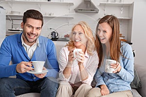 Young family with mother-in-law at home weekend drinking