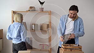 Young family moving to new apartments, hipster couple moving to new house, packing things in boxes, relocation