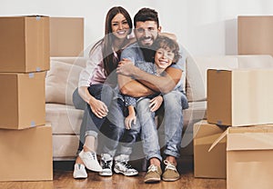 Young Family Moving to New Place and Sits on Sofa.