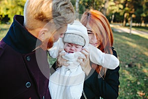 Young family and newborn son in autumn park