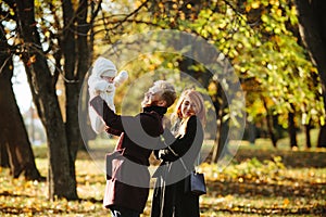 Young family and newborn son in autumn park