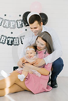 Young family with a one-year-old girl in his arms. Baby`s first birthday