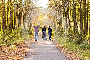 Young Family Outdoors Walking Through Autumn Park