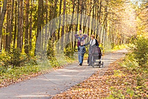 Young Family Outdoors Walking Through Autumn Park