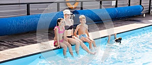 Young family, parents with children, in pool