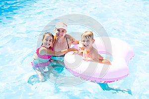 Young family, parents with children, in pool