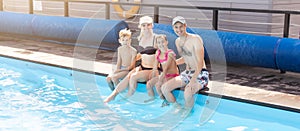 Young family, parents with children, in pool