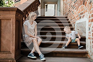 Young family. Parents sit with their son on the stairs. Mom and dad and your baby. Little boy.