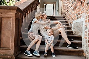 Young family. Parents sit with their son on the stairs. Mom and dad and your baby. Little boy.