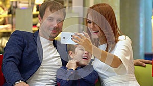 The young family is photographed all together. A selfie with purchases for Christmas. Lovely couple with the child in