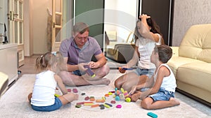A young family is playing board-games and relaxing at home