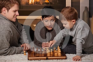 Young family playing chess