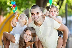 Young family playing colorful windmills with children