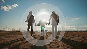 Young family playing in the field with soccer ball at sunset. Concept of friendly family.