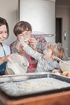 young family playing flour at messy kitchen