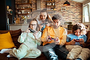 Young family playing video games together in the living room on a gaming console