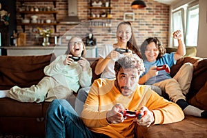 Young family playing video games together in the living room on a gaming console