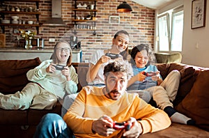 Young family playing video games together in the living room on a gaming console