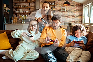 Young family playing video games together in the living room on a gaming console