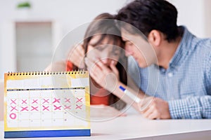 Young family in pregnancy planning concept with ovulation calend