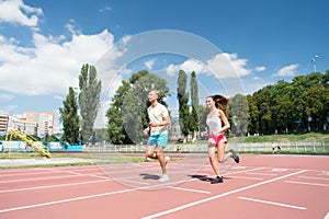 Young family promoting healthy lifestyle. Woman and man run stadium. Couple runners training outdoors. Couple or family