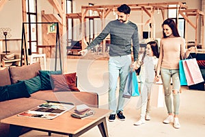 Young Family With Purchase Bags. Furniture Store.