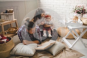 Young family reading story indoors