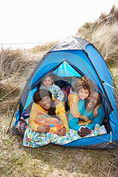 Young Family Relaxing Inside Tent On Holiday