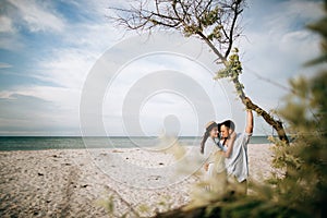 A young family is resting at sea, walking on a deserted sea beach on a sunny day