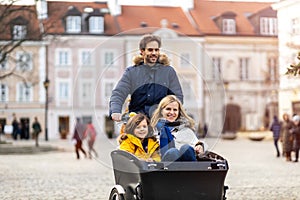 Young family riding in a cargo bicycle