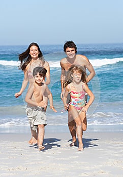 Giovane famiglia correre lungo Spiaggia sul vacanza 